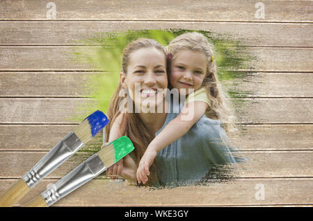 Immagine composita della madre e figlia nel parco contro la superficie di legno con dei pennelli Foto Stock