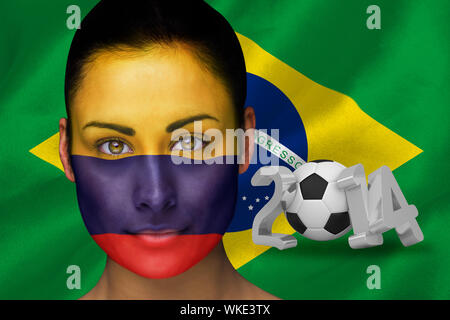 Immagine composita della Colombia appassionato di calcio in faccia vernice contro di coppa del mondo 2014 con brasil bandiera Foto Stock