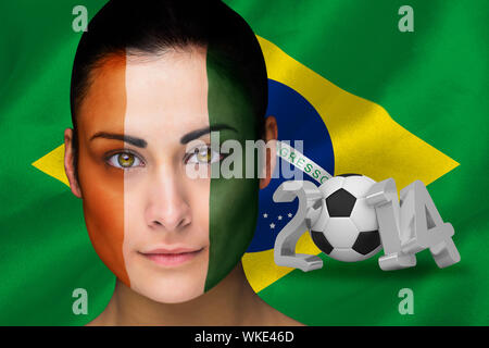 Immagine composita della Costa d'Avorio appassionato di calcio in faccia vernice contro di coppa del mondo 2014 con brasil bandiera Foto Stock