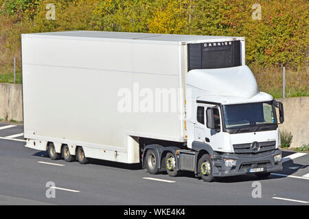 Lato anteriore e di bianco pulito non marcati consegna articolato rimorchio con scambiatore di calore Carrier & white hgv Mercedes camion unità carrello guida lungo l'autostrada UK Foto Stock