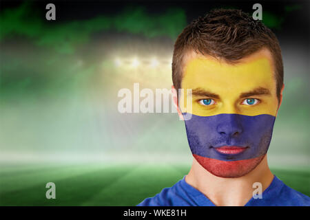 Immagine composita della Colombia appassionato di calcio in faccia vernice contro di calcio sotto il cielo verde e faretti Foto Stock