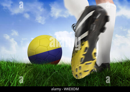 Immagine composita di scarpa da calcio calci colombia sfera contro campo di erba sotto il cielo blu Foto Stock