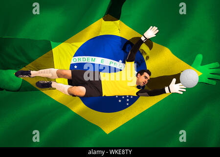 Il portiere in giallo effettuare un salvataggio contro generati digitalmente brasiliano bandiera nazionale Foto Stock