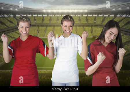Immagine composita di vari appassionati di calcio contro il grande stadio di calcio con ventole in giallo Foto Stock