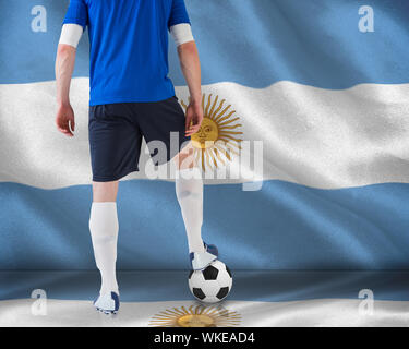 Immagine composita del giocatore di football in piedi con la sfera contro bandiera argentina Foto Stock