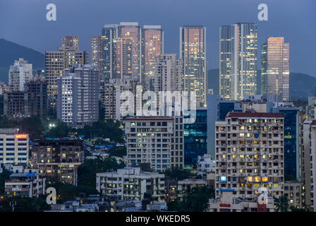 INDIA, Mumbai, grattacielo nel sobborgo Goregoan durante il crepuscolo, blu ora illuminata di windows, luci della città Foto Stock