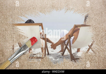 Immagine composita del giovane sulla spiaggia in sedie a sdraio con pennello immerso in rosso contro la superficie spiovente Foto Stock