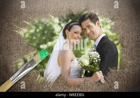 Immagine composita di sposi sorridente in telecamera con pennello immerso nel verde contro la superficie spiovente Foto Stock