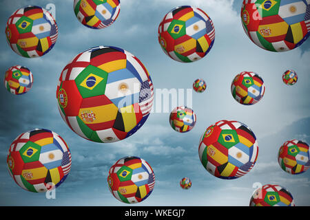 Palloni da calcio in bandiere internazionali contro il paesaggio del deserto Foto Stock