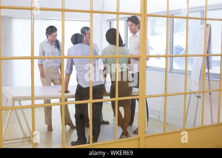 Aziendale attraente persone che parlano gli uni con gli altri e per la discussione di questioni aziendali insieme Foto Stock