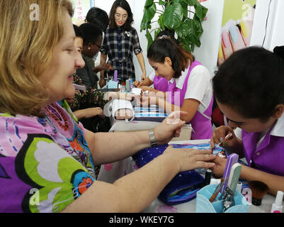 (190904) -- URUMQI, Sett. 4, 2019 (Xinhua) -- i membri dell'ONU inviati delegazione manicure esperienza presso un centro di formazione professionale ad Hotan contea di Hotan Prefettura, a nord-ovest della Cina di Xinjiang Uygur Regione autonoma, il 30 agosto 2019. Una delegazione di inviati speciali dell'ONU provenienti da otto paesi ha visitato a nord-ovest della Cina di Xinjiang Uygur Regione autonoma per ottenere una comprensione migliore della regione i traguardi raggiunti da de-radicalizzazione allo sradicamento della povertà. Il tour di cinque giorni li ha portati alla capitale regionale Urumqi e Hotan e Kashgar nel sud del Xinjiang, dove hanno visitato le fabbriche, bazaa Foto Stock