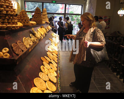 (190904) -- URUMQI, Sett. 4, 2019 (Xinhua) -- un membro dell'ONU inviati gli orologi della delegazione "Nang", una sorta di crosta di pancake, al grand bazaar in Urumqi, capitale del nord-ovest della Cina di Xinjiang Uygur Regione autonoma, Agosto 28, 2019. Una delegazione di inviati speciali dell'ONU provenienti da otto paesi ha visitato a nord-ovest della Cina di Xinjiang Uygur Regione autonoma per ottenere una comprensione migliore della regione i traguardi raggiunti da de-radicalizzazione allo sradicamento della povertà. Il tour di cinque giorni li ha portati alla capitale regionale Urumqi e Hotan e Kashgar nel sud del Xinjiang, dove hanno visitato le fabbriche, bazar, Foto Stock