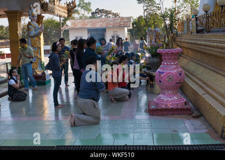 Persone in preghiera presso la Kyaik Pun Pagoda, Myanmar Foto Stock