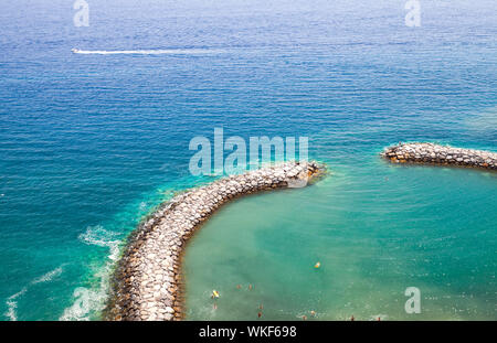 Le persone a nuotare in una piccola laguna protetta con frangiflutti. Calheta, isola di Madeira, Portogallo Foto Stock