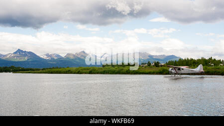 Un piano bush esegue il decollo in Alaska con Chugach Mountains in background Foto Stock