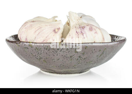 Il gruppo di quattro tutto bianco organico aglio allium sativum in scuro vaso in ceramica isolata su sfondo bianco Foto Stock