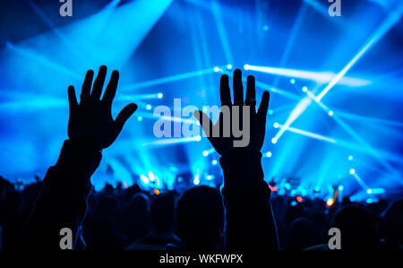 Concerto di musica, silhouette di Le Mans in alto le mani, la folla di gente, attiva vita notturna, vacanze celebrazione in dance club, il piacere e il divertimento concept Foto Stock