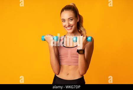 Montare allegra ragazza che lavora fuori con manubri in Studio Foto Stock