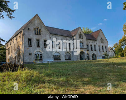 Neustrelitz, Germania. 25 Ago, 2019. Da decenni gli edifici vuoti dell'ex Landesirrenanstalt sul Domjüch. La zona remota all'Domjüchsee era fino al 1945 un regionale manicomio con otto edifici, poi una caserma russa, è stato vuoto dal 1993 e oggi è mantenuta dall'associazione per la salvaguardia del Domjüch e utilizzato per vari eventi. Credito: Jens Büttner/dpa-Zentralbild/ZB/dpa/Alamy Live News Foto Stock