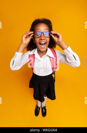 Black Schoolgirl urlando guardando la telecamera, High-Angle Studio Shot Foto Stock