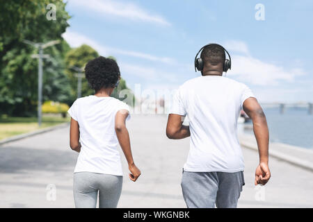 Irriconoscibile Afro giovane fare jogging lungo il fiume Embankment Foto Stock