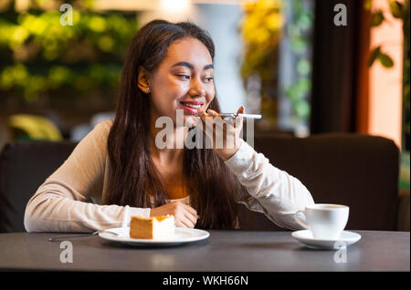 Ragazza giovane e carina la registrazione del messaggio vocale sul telefono cellulare Foto Stock