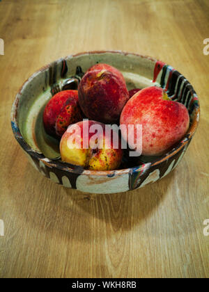 Tradizionale dipinto a mano vaso di argilla con pesche prelevata dal giardino Foto Stock