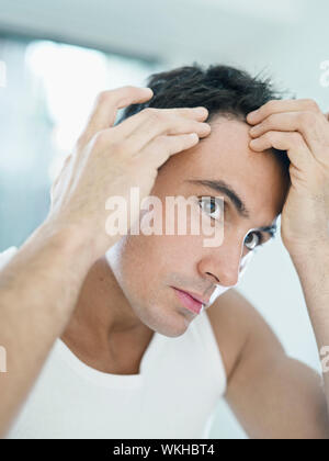 Caucasian uomo adulto controllo linea di demarcazione. Forma verticale, la testa e le spalle Foto Stock