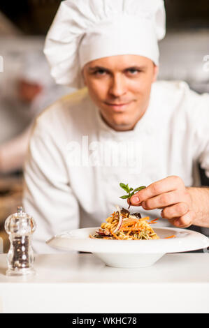 Chef di aggiungere il tocco finale a una deliziosa insalata Foto Stock