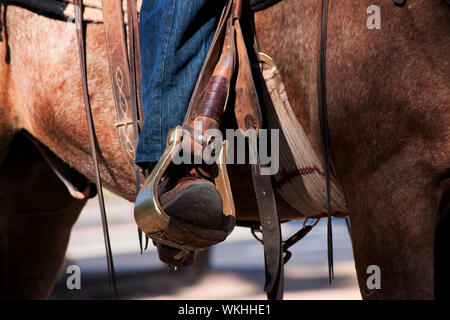 Cowboy è la gamba e il piede nella staffa a cavallo Foto Stock