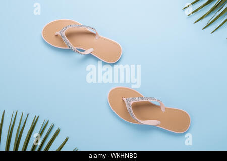 Donna bella spiaggia del flip-flop sulla luce blu pastello sfondo. beach estate concetto e concetto di vacanza, vista dall'alto, camminare in estate Foto Stock