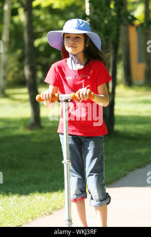 Ragazza in sella il suo scooter in estate Foto Stock