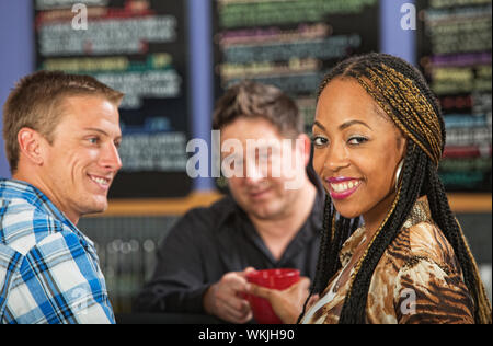 Bella sorridente donna nera con caffè nella caffetteria Foto Stock