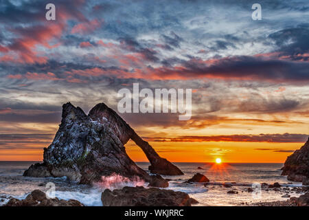 BOW FIDDLE ROCK PORTKNOCKIE MORAY Scozia colorato spettacolare inizio alba con rosa SEA SPRAY sulle rocce in estate Foto Stock