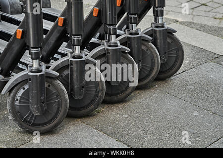 Hannover, Germania, Agosto 24, 2019: Ruote di e-scooter parcheggiato a fianco a fianco per il noleggio sul marciapiede Foto Stock