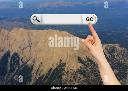 Mano umana indica la barra di ricerca nel browser. Montagna e cielo sullo sfondo Foto Stock