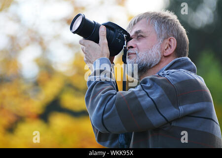 Senior uomo cercando motivo con la fotocamera Foto Stock