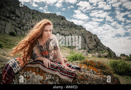 Ragazza giovane a praticare lo yoga nel parco. La calma e la meditazione. I giovani i Capelli rossi ragazza sotto un albero rilassa Foto Stock