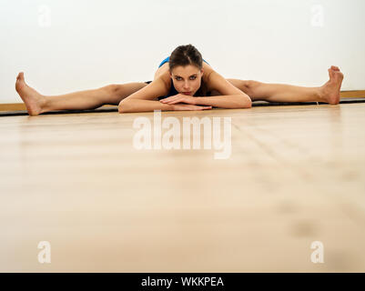 Foto di una giovane donna bellissima facendo le spaccature durante un allenamento. Foto Stock