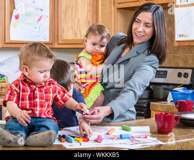 Una madre in cucina gioca con il suo bebè Foto Stock