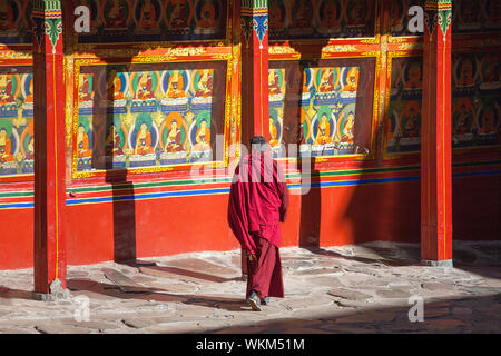 Un monaco tibetano passeggiate in un cortile interno nel monastero Tashilhunpo, Shigatse, nel Tibet Foto Stock