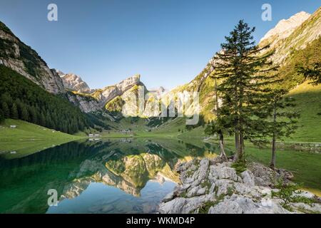 Le montagne si riflette a sunrise nel lago Seealpsee, dietro Santis, Alpstein, cantone di Appenzell, Svizzera Foto Stock