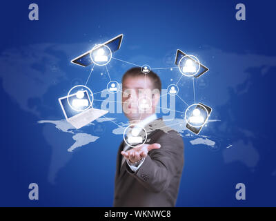 Business man in suit tenere il telefono, laptop, tablet e la mappa del mondo. Concetto di tecnologia Foto Stock