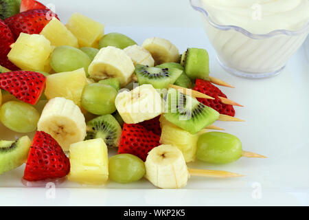 Frutta fresca Kebab fatta di fragole, uva, kiwi, banane e ananas. Profondità di campo Foto Stock