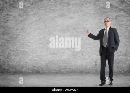 Asian business man introdurre con parete di vuoto in una stanza. Foto Stock
