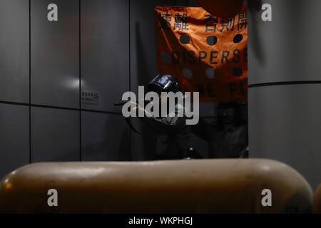 Hong Kong, Cina. 5 Sep, 2019. Poliziotto proteggendo l'ingresso di Mong Kok stazione di polizia finalizzate alla raccolta di manifestanti fuori della stazione con un fucile. Hong Kongers continuare con le loro proteste dopo la RASHK Chief Executive Carrie Lam ha annunciato il ritiro completo della legge in materia di estradizione ieri.Sept-5, 2019 Hong Kong.ZUMA/Liau Chung-ren Credito: Liau Chung-ren/ZUMA filo/Alamy Live News Foto Stock