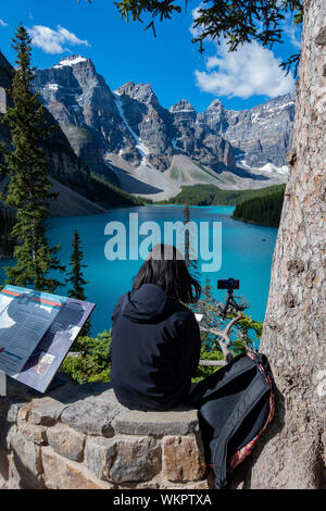 Donna di scattare una foto del Lago Moraine presso il Parco Nazionale di Banff, Canada Foto Stock