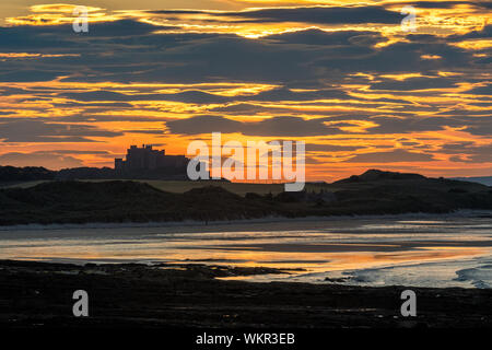 Il castello di Bamburgh e al tramonto, Northumberland, Regno Unito Foto Stock