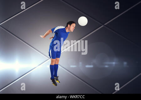 Giocatore di football in blu jumping contro schermo futuristico con linee Foto Stock