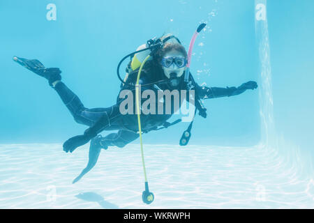 Donna sulla formazione di scuba immersi nella piscina sul suo vacanze Foto Stock